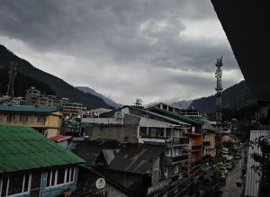 a group of buildings in a city with mountains at Hotel Premier Mall Road Manali in Manāli