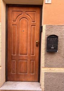 eine Holztür auf einem Gebäude mit einem Briefkasten in der Unterkunft Sirtori 8A in Quartu SantʼElena