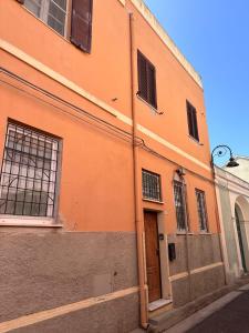 een oranje gebouw met een deur in een straat bij Sirtori 8A in Quartu SantʼElena