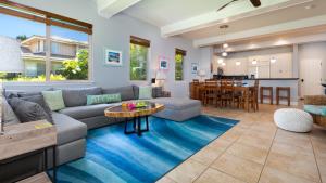 een woonkamer met een bank en een tafel bij HAWAIIANA ESCAPE Tropical 3BR Kulalani Home with Bikes and Beach Club in Waikoloa