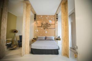 een slaapkamer met een bed met een bord aan de muur bij Albergo Diffuso Dimora Rossi Suite B&B in Turi