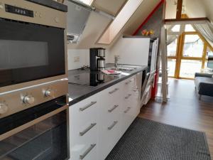 una cucina con piano cottura e forno a microonde di Dachspitz - junges Wohnen a Unterkirnach