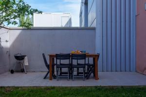 una mesa y sillas en un patio en Le Loft D'Oc - Duplex 117m2 - 2 chambres et jardin, en Launaguet