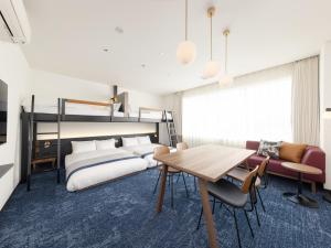 a bedroom with two beds and a table and chairs at &Here TOKYO UENO in Tokyo