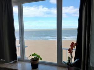 - une vue sur la plage depuis la fenêtre dans l'établissement Suite Kursaal met zeezicht, à Ostende