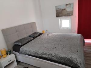 Ce lit se trouve dans une chambre dotée d'un mur rouge et blanc. dans l'établissement Ema, à Šibenik