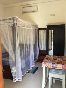 a room with two beds and a table in it at Aroma Guest House in Mirissa