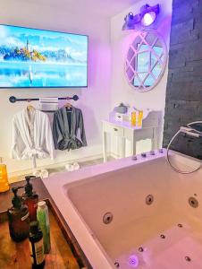 bañera en una habitación con TV en Logements Ault - Détente et Confort en Baie de Somme, en Ault