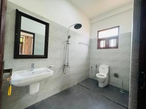 a bathroom with a sink and a toilet at Hikka Garden Villa in Hikkaduwa +6 photos