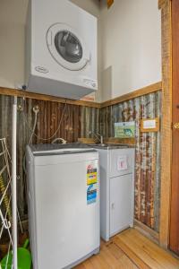 une cuisine avec un réfrigérateur et un micro-ondes dans l'établissement StayAU Cottage Sunset 2BR Farm Retreat, à Badger Creek 10 autres photos