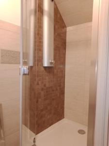 La salle de bains est pourvue d'une douche avec une porte en verre. dans l'établissement Le Baugyte - Gite de GROUPE - 14 lits simples, à Marcigny