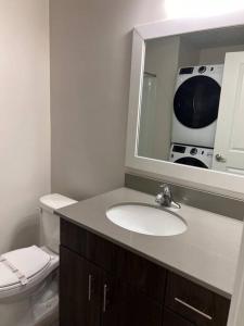a bathroom with a sink and a toilet and a mirror at One bedroom apartment in Salt Lake City