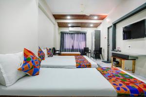 A bed or beds in a room at FabHotel Priya Lodging, near Ojhar Airport