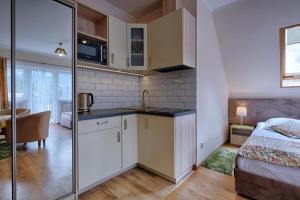 a bedroom with a bed and a kitchen with a sink at Pensjonat Dawidek in Zakopane +118 photos