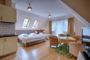 a bedroom with two beds and a living room at Pensjonat Dawidek in Zakopane