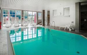 a large swimming pool with blue water in a building at Feriendorf Schwarzholz in Viechtach