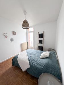 Schlafzimmer mit einem Bett mit blauer Decke in der Unterkunft Appartement vue Parc Montjuzet avec garage in Clermont-Ferrand