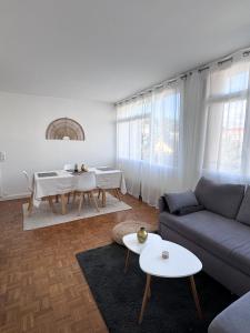 ein Wohnzimmer mit einem Sofa und einem Tisch in der Unterkunft Appartement vue Parc Montjuzet avec garage in Clermont-Ferrand