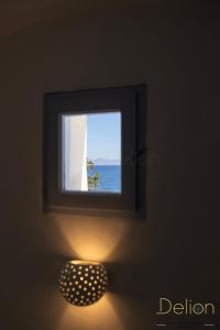 ein Bild eines Fensters in einem Zimmer mit einer Lampe in der Unterkunft DELION SEA APARTMENTS in Kamari