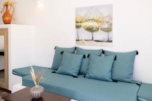 un divano con cuscini blu in soggiorno di DELION SEA APARTMENTS a Kamari