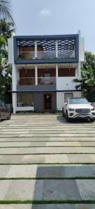 a white car parked in front of a building at Waterlily Homestay in Kottayam