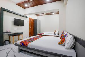 a bedroom with a bed and a television in it at FabHotel Priya Lodging, near Ojhar Airport in Nashik