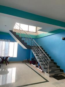 a staircase in a room with a blue wall at The Roll oak Homestay in Mangpu