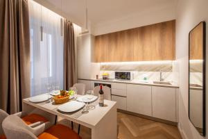 eine Küche mit einem Tisch und Weingläsern darauf in der Unterkunft Novos Emerald - Happy Rentals in Lugano