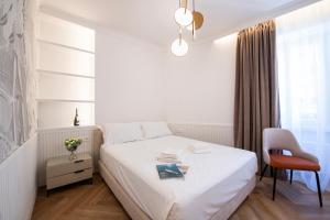 ein weißes Schlafzimmer mit einem Bett und einem Stuhl in der Unterkunft Novos Emerald - Happy Rentals in Lugano
