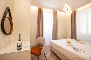 ein Hotelzimmer mit einem Bett, einem Stuhl und einem Spiegel in der Unterkunft Novos Emerald - Happy Rentals in Lugano