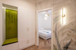 ein Schlafzimmer mit einem Bett und einer grünen Wand in der Unterkunft Novos Emerald - Happy Rentals in Lugano