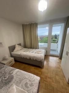 1 Schlafzimmer mit 2 Betten und einem großen Fenster in der Unterkunft Big Und Bequem in Hannover