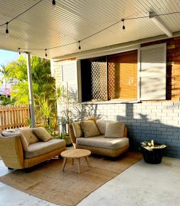 a patio with two couches and a table at Holiday on Hibiscus in Urangan