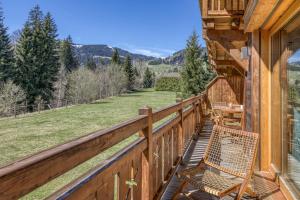 a balcony with a table and chairs on a house at Appartement Chalet à Megève in Megève