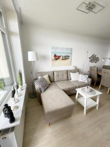 un soggiorno con divano e tavolo di Vier Jahreszeiten 3-83 a Grossenbrode