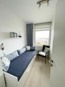 una camera con un letto, una finestra e una sedia di Vier Jahreszeiten 3-83 a Grossenbrode