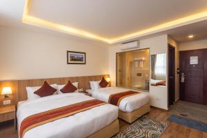Rúm í herbergi á Hotel Crystal Pashupati