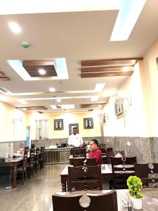 twee mensen aan tafel in een restaurant bij Hotel Royal Inn igi in New Delhi