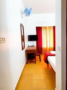 a room with a bedroom with a desk and a bed at Exotica Holidays in Viripara