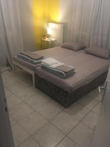- une chambre avec un lit et des serviettes dans l'établissement JIM, à Andravída
