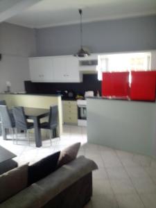 salon i kuchnia z kanapą i stołem w obiekcie JIM w mieście Andravída