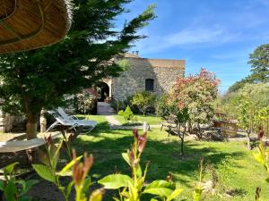 une maison en pierre avec un jardin en face dans l'établissement Chambres d'hôtes - Mulino nannaré, à Ville-di-Paraso