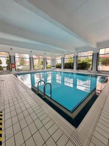 a large swimming pool in a building with windows at AL-DOM apartamenty Grey 112 Olymp in Kołobrzeg +13 photos