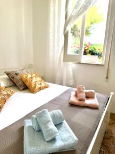 - deux serviettes assises au-dessus d'un lit dans l'établissement Nella spiaggia più bella, à Santa Maria Del Focallo