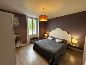 a bedroom with a bed with two pillows on it at Les Appart'confort in Bain-de-Bretagne