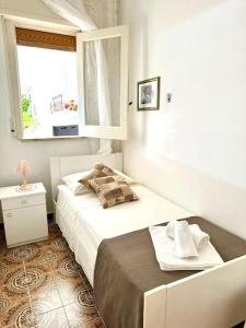 - une chambre blanche avec un lit et une fenêtre dans l'établissement Nella spiaggia più bella, à Santa Maria Del Focallo