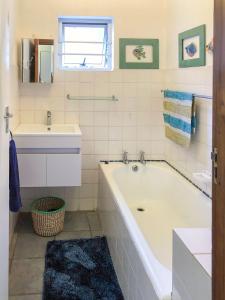 a white bathroom with a tub and a sink at Pumlani Kei Mouth in Kei-mouth Village