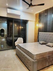 a bedroom with a bed with a ceiling fan at VelvetHouz Luxury Studio Apartment In Noida in Ghaziabad
