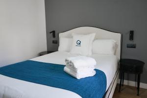 ein Schlafzimmer mit einem weißen Bett und Handtüchern darauf in der Unterkunft Aqua Apartments Málaga in Málaga