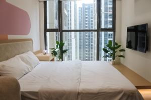 een groot wit bed in een kamer met grote ramen bij SISO homestay - Enchanting Studio in Hanoi